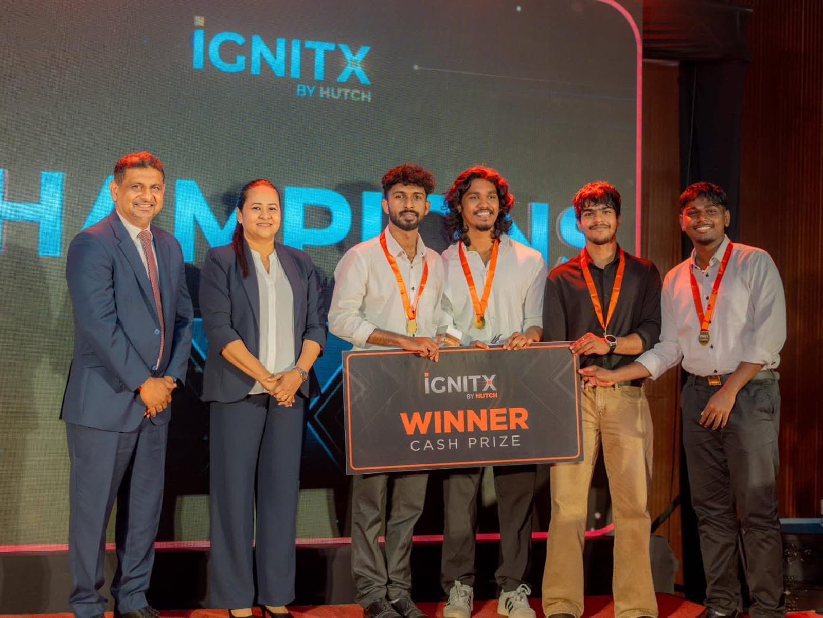 Team Zeptaz on stage with HUTCH leadership, holding the IgnitX winner board